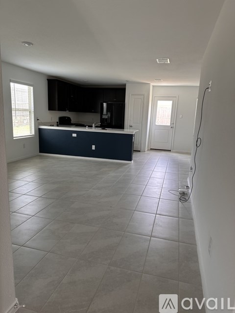 A kitchen with a blue island and white walls.