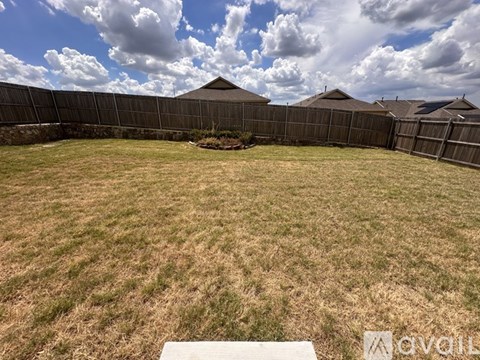 A backyard with a wooden deck and a fence.