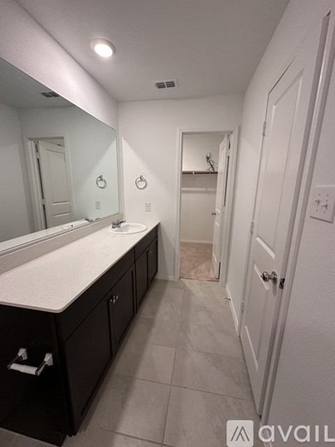 A bathroom with a sink, mirror, and cabinets.