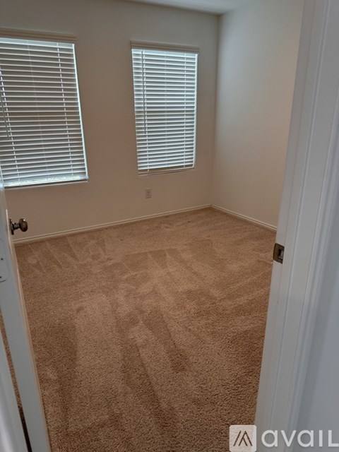 A room with beige carpet and white walls.