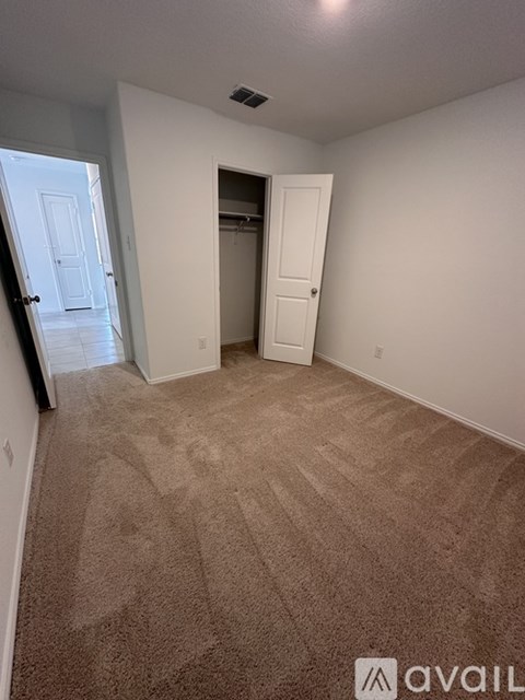 A room with carpeted floor and two doors.