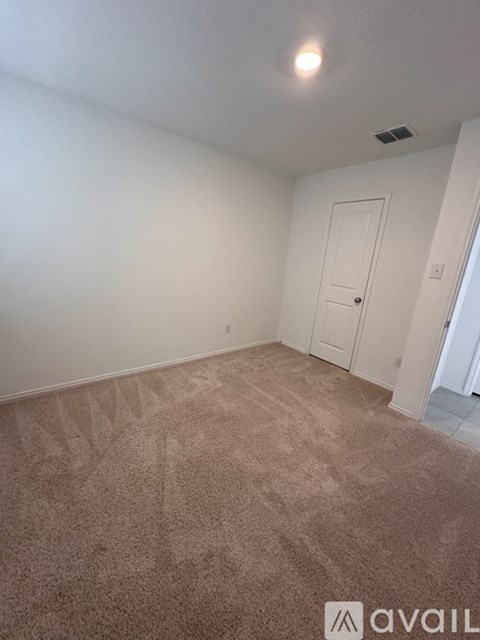 A room with a carpeted floor and a door.