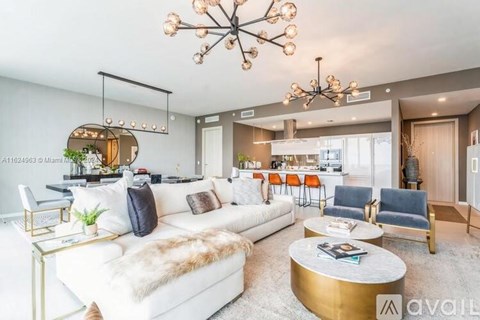 A modern living room with a white sofa and a gold coffee table.