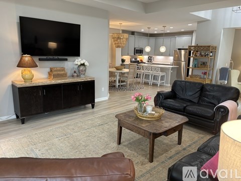 A living room with a brown leather couch and a wooden coffee table.