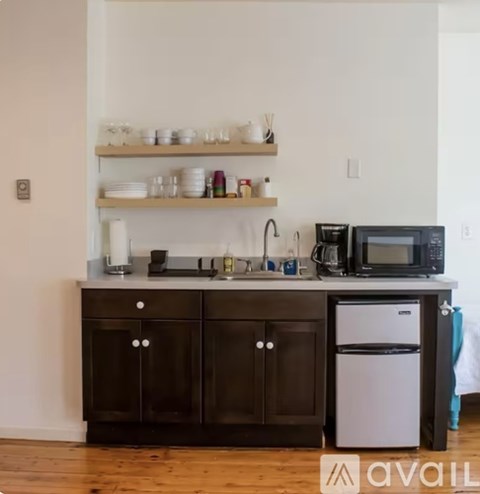 A kitchen with a black cabinet and a white fridge.