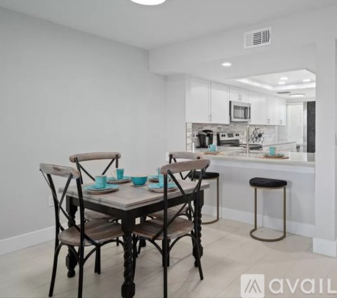 A kitchen with a table and chairs in the foreground.