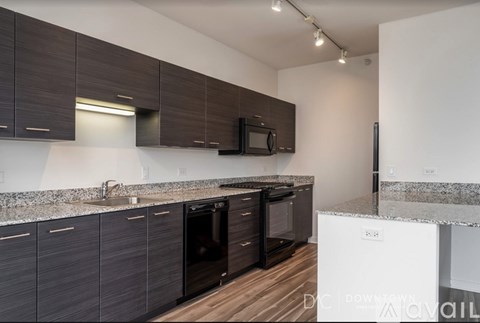 A kitchen with dark brown cabinets and a white counter.