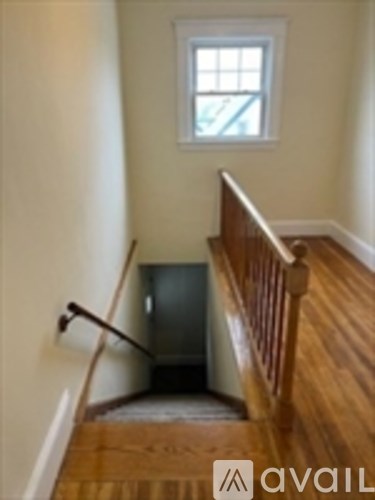 A wooden staircase with a window above it.