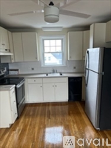A kitchen with a refrigerator on the right side.