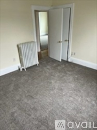A room with a carpeted floor and a white door.