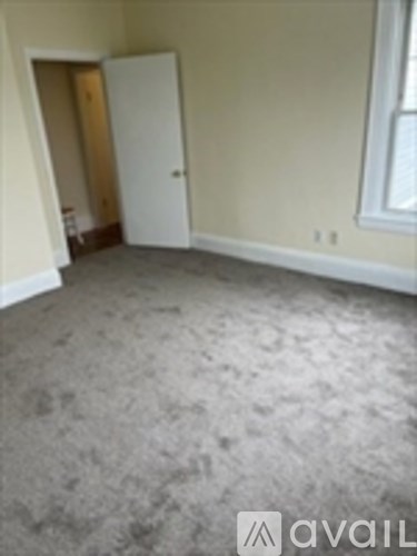 A room with a carpeted floor and a door.