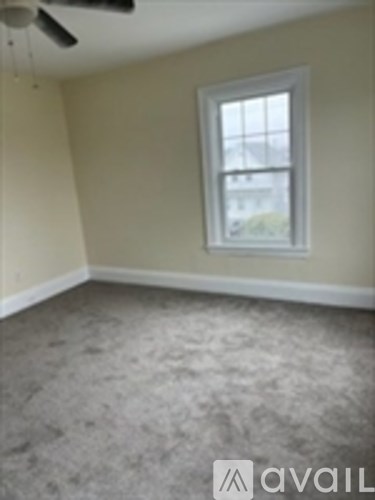 A room with a window and a ceiling fan.