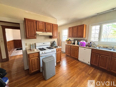 A kitchen with wooden cabinets and a white stove top oven.