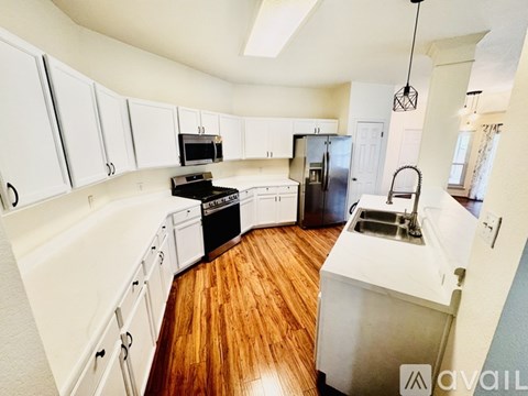 A kitchen with white cabinets and a black stove top oven.