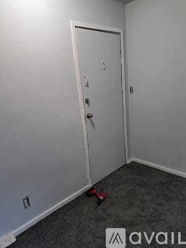 A room with a white door and a red object on the floor.
