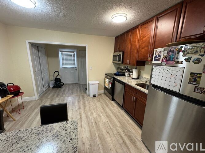 A kitchen with a refrigerator, microwave, and dishwasher.