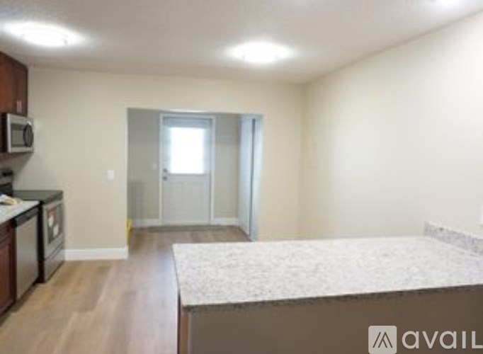 A bedroom with a bed, a microwave, and a fridge.