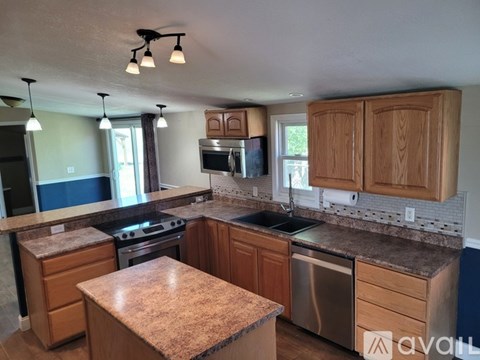 A kitchen with wooden cabinets and granite countertops.