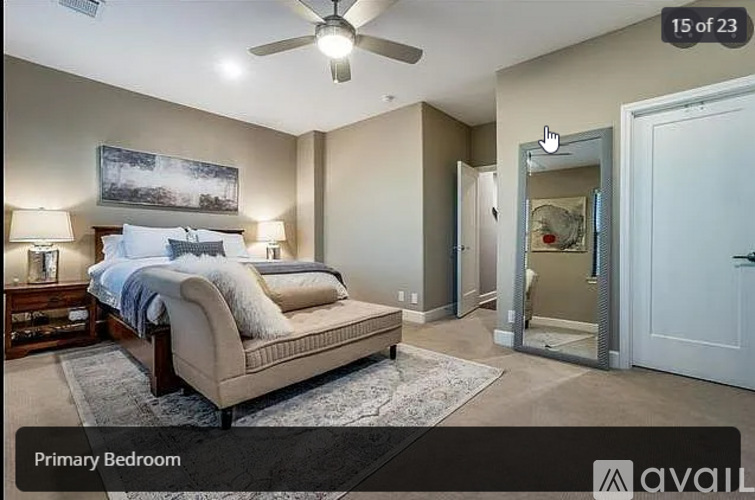 A bedroom with a large bed and a ceiling fan.