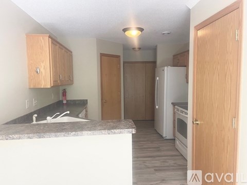 A kitchen with a white counter top and wooden cabinets.