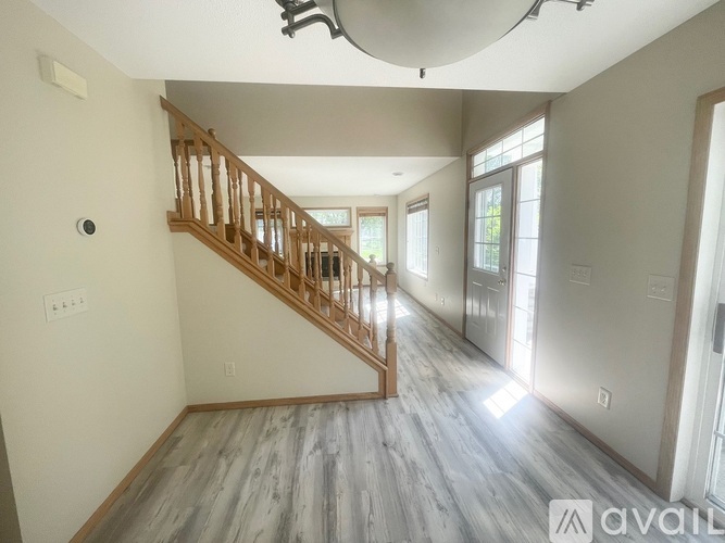 A spacious room with a wooden staircase and a skylight.