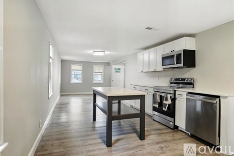 A kitchen with a table and stove top oven.