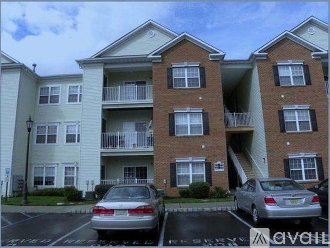 A two-story apartment building with a car parked in front.