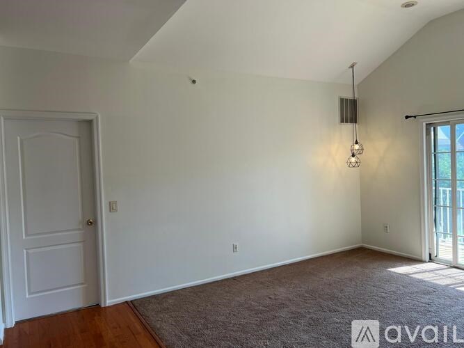 A room with a carpeted floor and a door on the left.