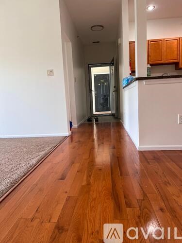 A room with a carpeted floor and a sliding glass door leading to a parking lot.