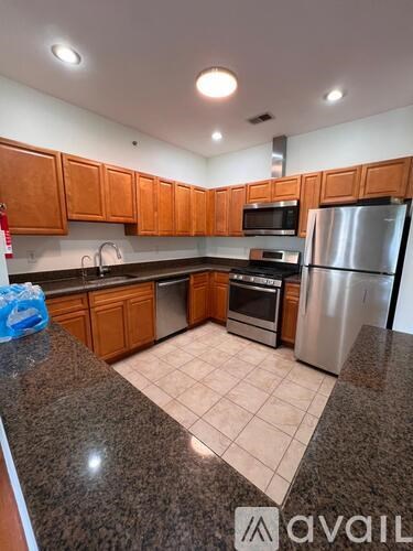 A kitchen with wooden cabinets and a white island.