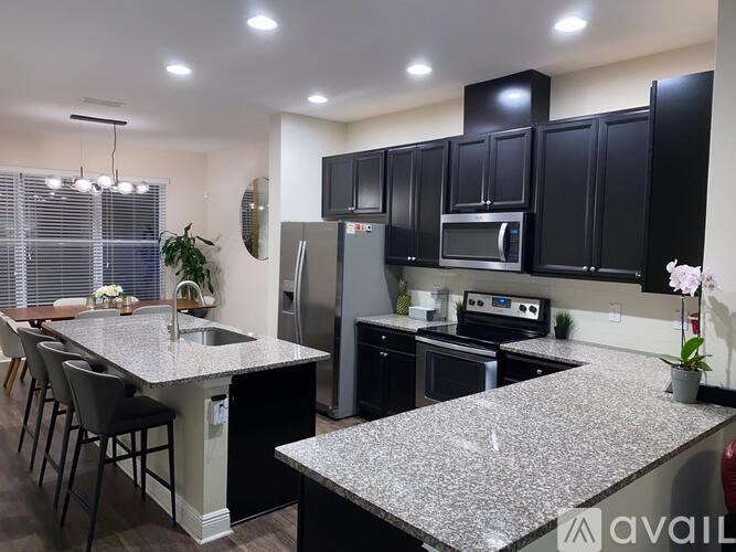 A kitchen with black cabinets and granite countertops.