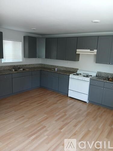 A kitchen with wooden floors and white appliances.