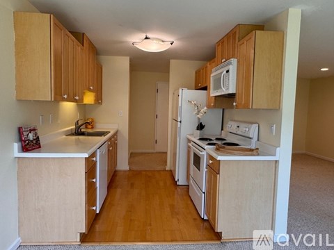 A kitchen with wooden cabinets and white appliances.