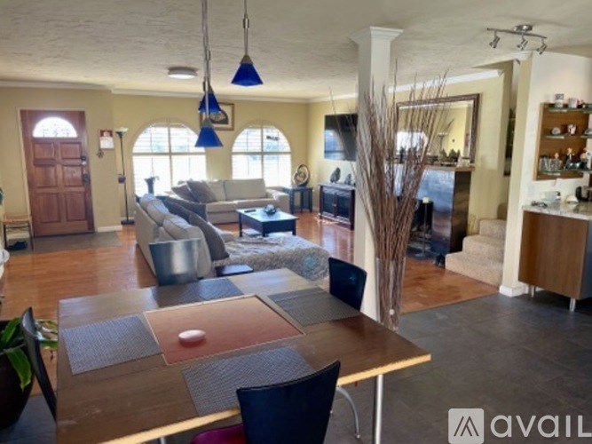 A living room with a couch, chairs, and a dining table.