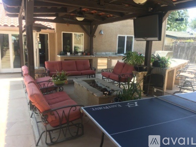 A patio with a table, chairs, and a pool table.