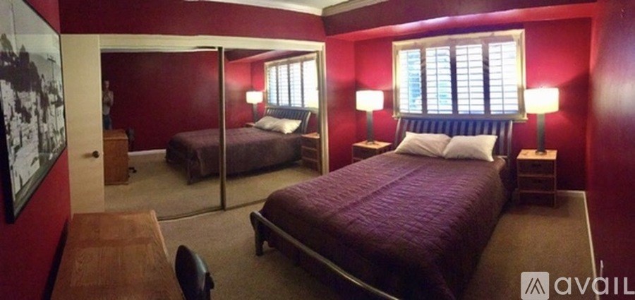 A bedroom with two beds and a table.