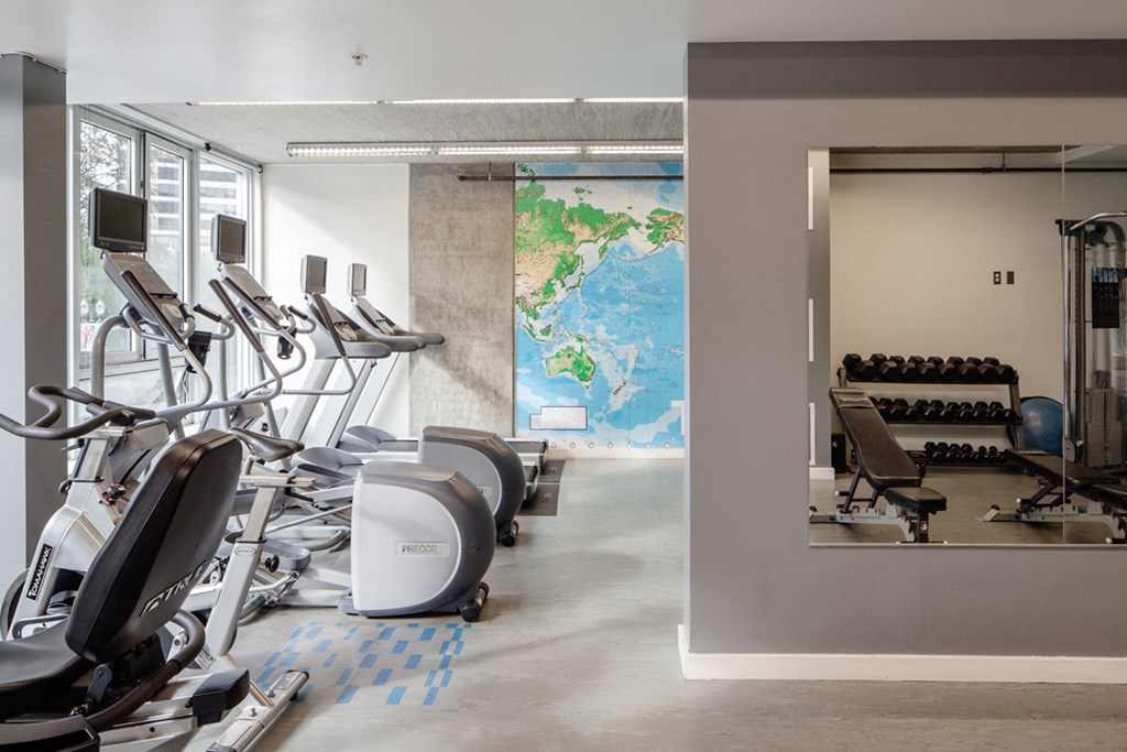 a gym with cardio machines and a map of the world on the wall