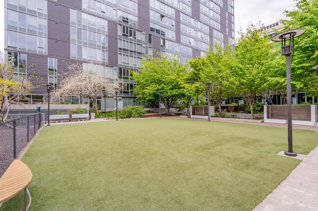 a yard with grass and trees in front of an office building