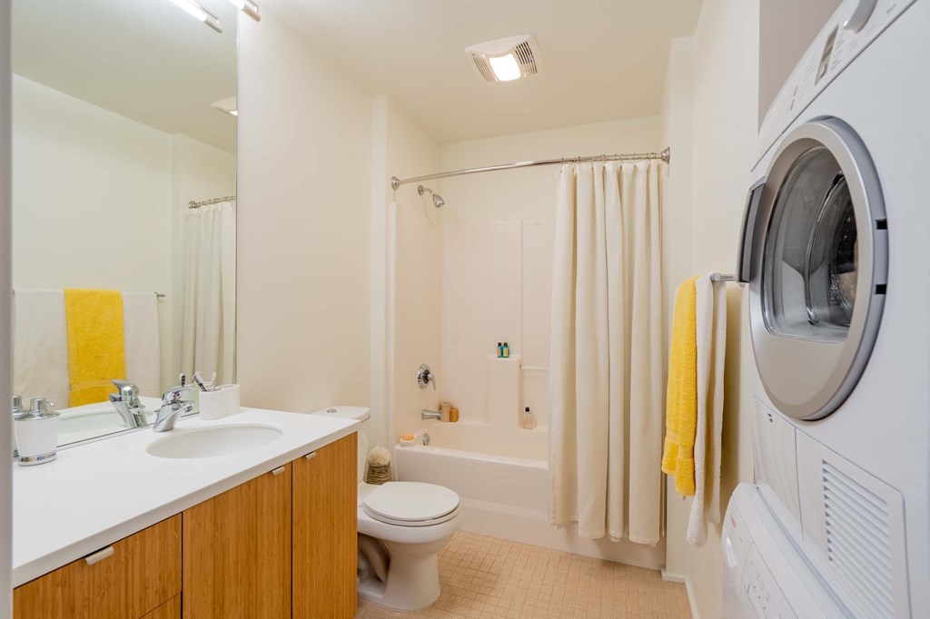 a bathroom with a toilet and a washer and dryer in it