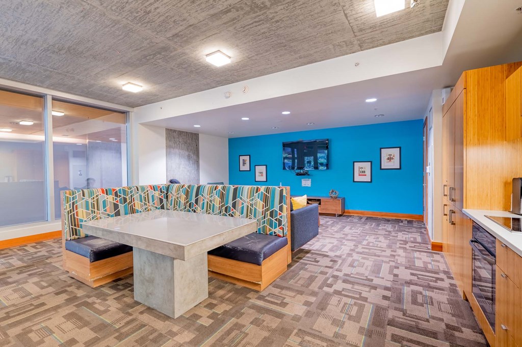 a communal table and seating area in a room with a blue wall