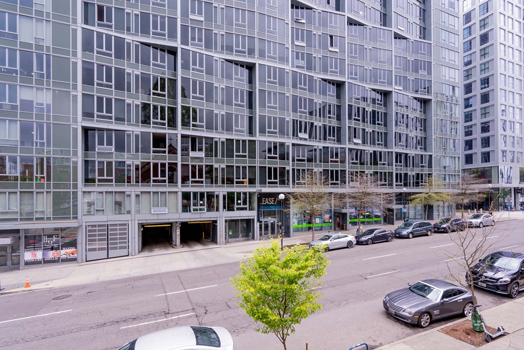 a city street with cars parked in front of a tall building