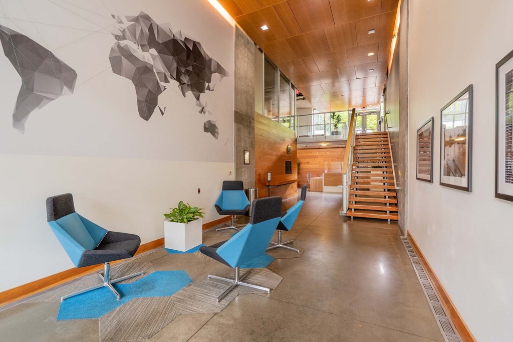 a lobby with chairs and a staircase and a map on the wall