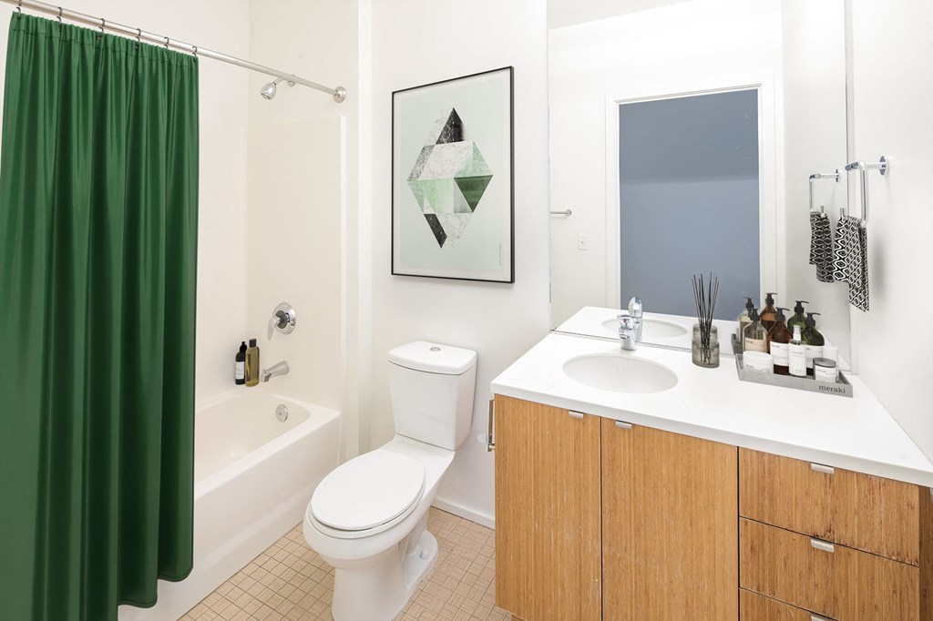 a bathroom with a green shower curtain and a white toilet