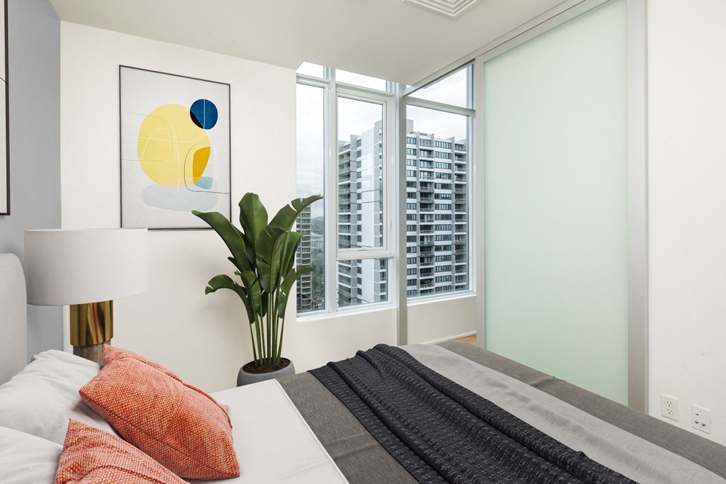 a bedroom with a bed and a large window