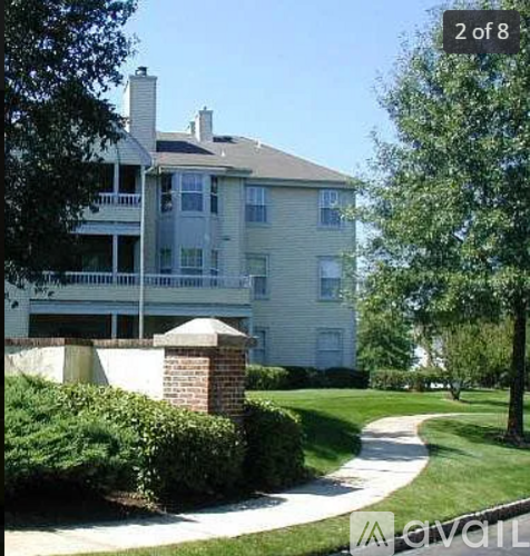 A large house with a balcony and a tree in front.