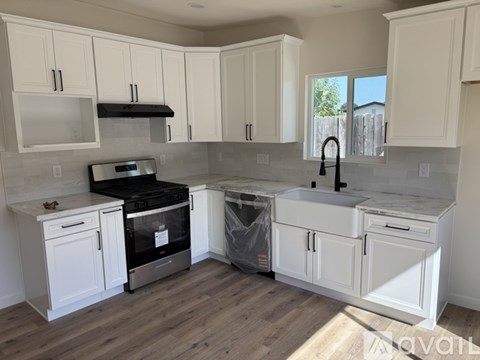 A kitchen with white cabinets and a black stove top oven.