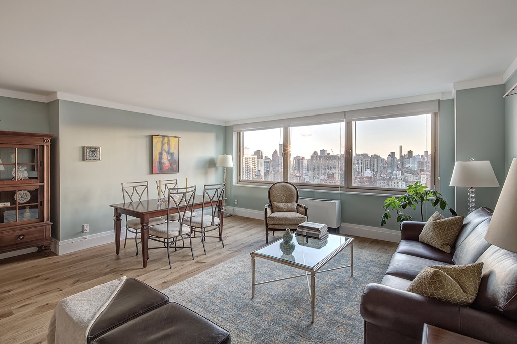 a living room with a couch and a table with chairs and a window