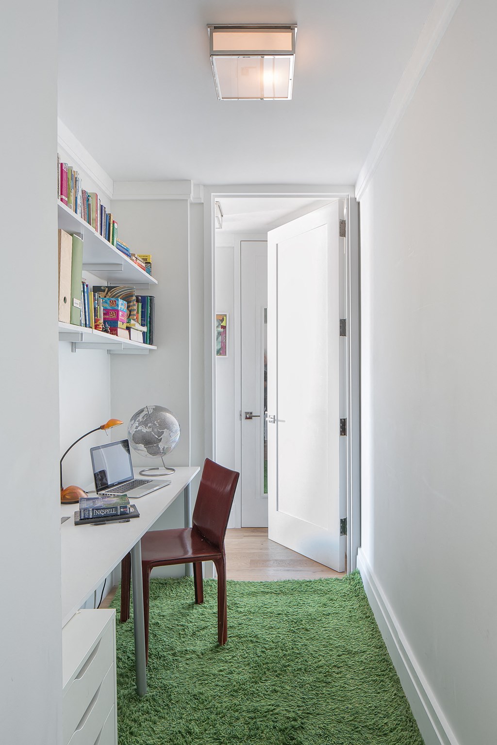 a home office with a desk and a green rug