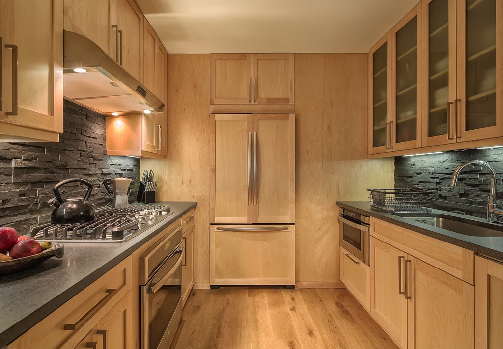 a kitchen with wooden cabinets and a stove and a refrigerator