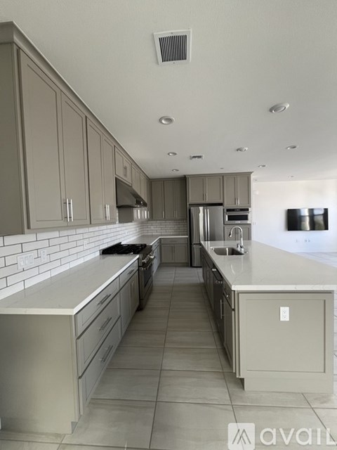 A modern kitchen with a long counter and a stove top oven.
